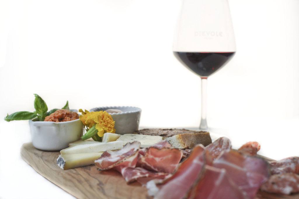 Il tagliere toscano è composto da: salumi, salsa, deliziosi formaggi e accompagnato da un buon bicchiere di vino rosso - Vino e formaggio